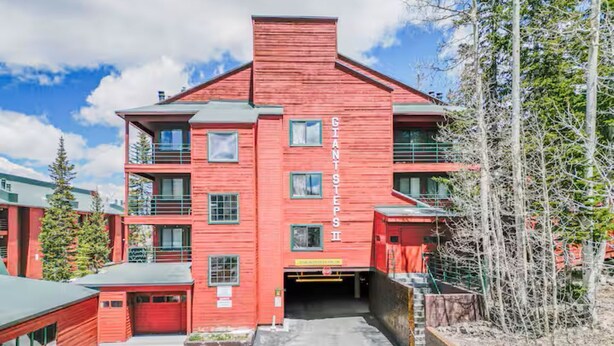 A red building with multiple balconies and a sign reading "GIANT STEPS." - Stay at Giant Steps, Ski in / Ski out, Sleeps 4, Full Kitchen (Brian Head)