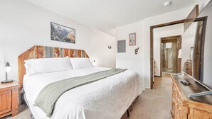 A bedroom with a large bed, wooden headboard, a dresser, and a mirror. - Stay at Giant Steps, Ski in / Ski out, Sleeps 4, Full Kitchen (Brian Head)