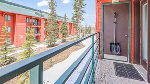 A red building with a balcony, a door with a shovel, and several trees in the background. - Stay at Giant Steps, Ski in / Ski out, Sleeps 4, Full Kitchen (Brian Head)
