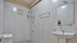 Un baño con inodoro, lavabo, espejo y ducha.