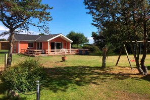 A residential property with a house, a lawn, a swing set, and a fenced area. - holiday home located on a 1400 m plot (Rudkøbing)
