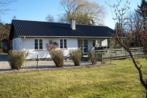 A single-story house with a black roof, white exterior, and a gravel driveway. - Holiday home just 400 meters from the water (Rudkøbing)