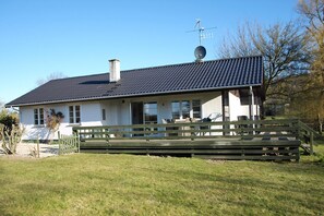 A house with a sloped roof, a satellite dish, and a wooden deck. - Holiday home just 400 meters from the water (Rudkøbing)