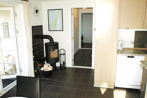 A kitchen with a stove, a refrigerator, and a map on the wall. - Holiday home just 400 meters from the water (Rudkøbing)