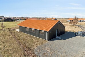 Ein eingeschossiges Gebäude mit Satteldach, einem Schotterweg und der Hausnummer 246 an der Seite.