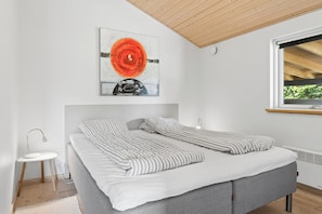 A modern bedroom with a bed, bedside table, and a window. - Lovely holiday home at Kongsmark Strand (Slagelse)