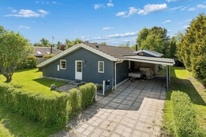 A single-story house with a covered patio, a well-maintained lawn, and a clear sky. - Lovely holiday home at Kongsmark Strand (Slagelse)