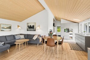 Un intérieur moderne comprenant un coin repas, une cuisine et un espace de vie.