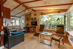 A cozy living room with a sofa, chairs, a TV, and a fireplace. - Charming vacation home on large grounds (Rudkøbing)