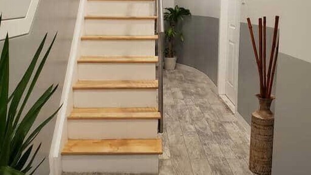 Eine Treppe mit Holzbodenstufen, die zu einer Zwischenebene führt.