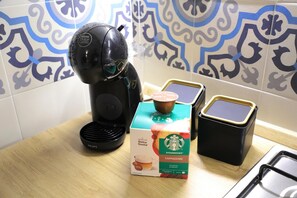 A coffee maker, a box of Starbucks cappuccino coffee, and two containers of coffee on a kitchen counter. - Old town apartment, new and cozy (Napoli)