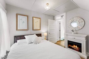 A bedroom with a bed, a fireplace, and two framed pictures on the wall. - 5BR home* Minutes to DT, Venues & Breweries (Minneapolis)