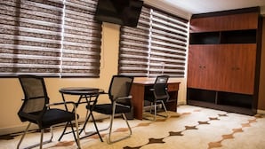 A room with a desk, two chairs, a television, and a wardrobe. - HOTEL PAIRUMANI (Cochabamba)