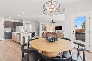 Una cucina moderna con zona pranzo, ventilatore a soffitto e televisione che mostra 'NETFLIX'.