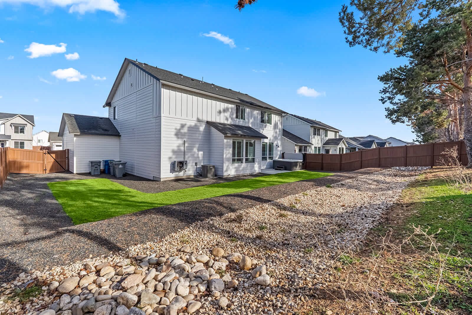 A two-story house with a well-maintained lawn and a gravel driveway.