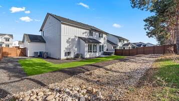 A two-story house with a well-maintained lawn and a gravel driveway.