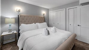 A neatly made bed with white linens and towels, a bedside lamp, and a nightstand. - Serene Birmingham Retreat (Birmingham)