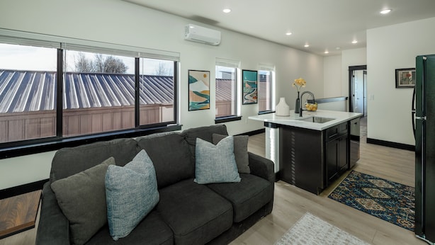 A modern kitchen with a central island, a built-in sink, and a refrigerator.
