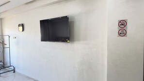 A room with a mounted flat-screen TV, a no-smoking sign, and a WiFi sign on the wall. - Studio Karatchi Centre Casablanca (Casablanca)