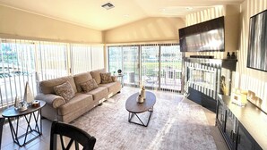A spacious living area with a sofa, coffee table, and dining table.