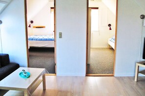Ein Zimmer mit einem Bett, einem kleinen Tisch und einer Tür zu einem anderen Raum.