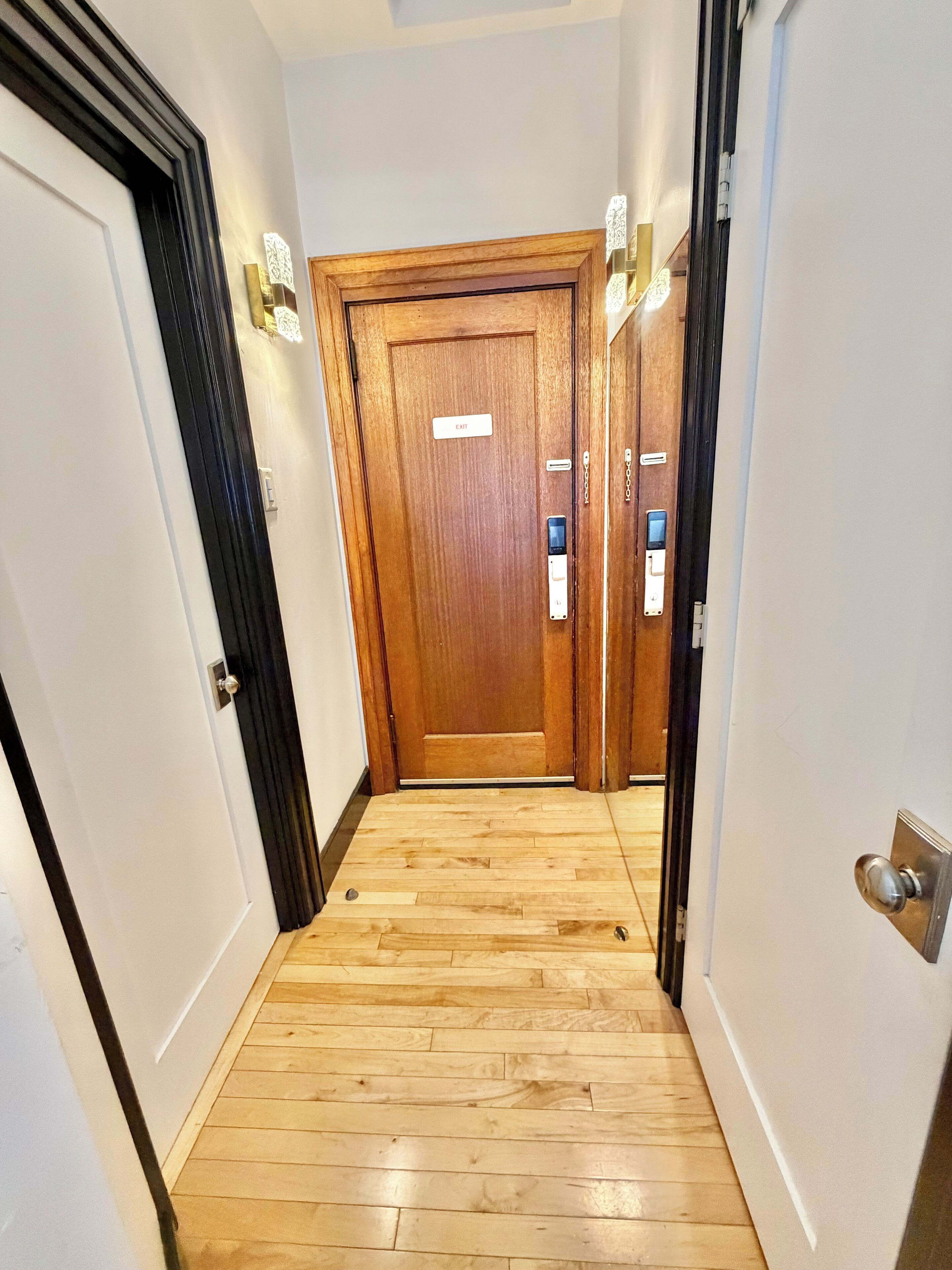 A hallway with a wooden door marked "EXIT" and a keypad lock.