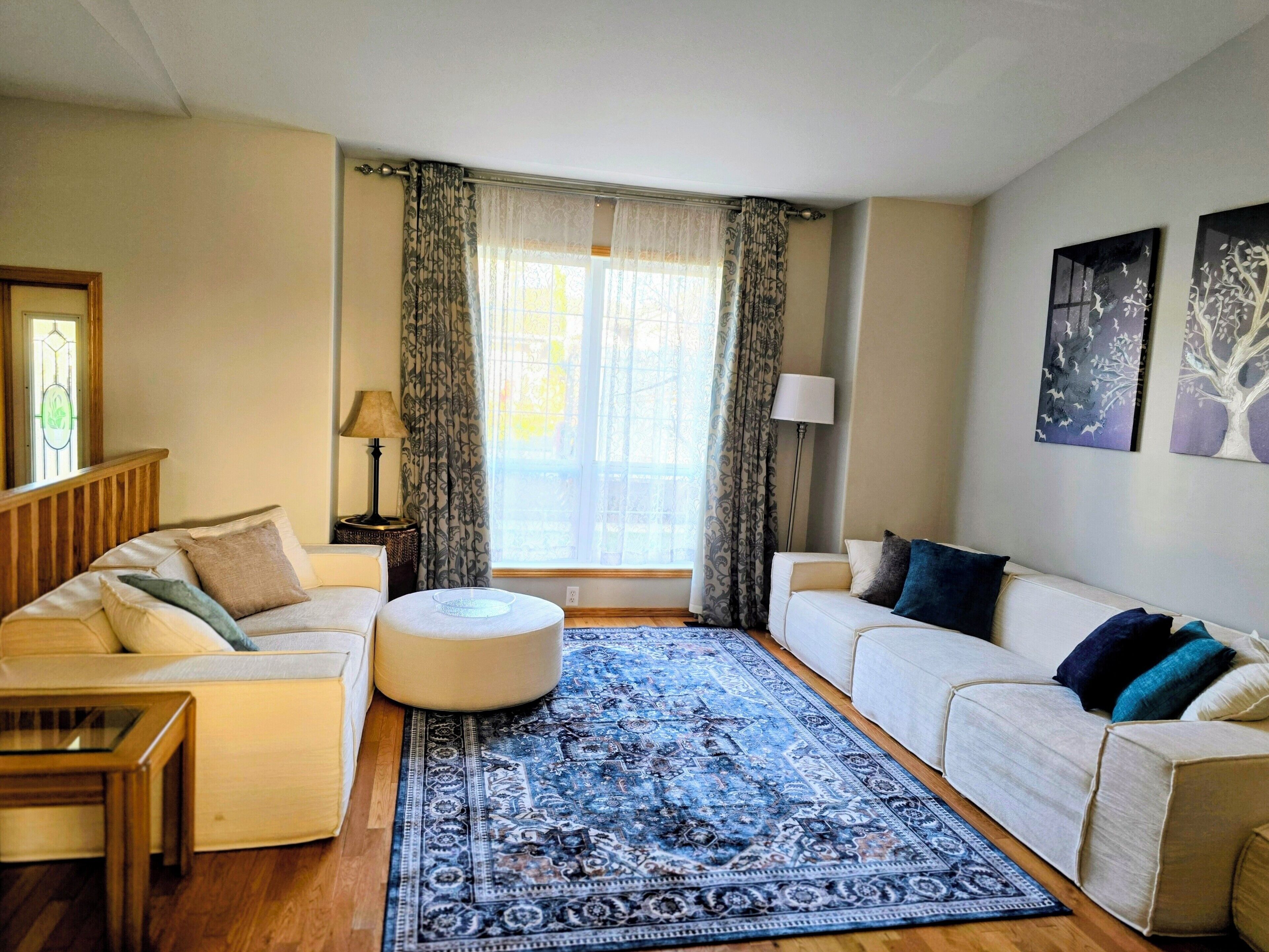 A living room with two sofas, a coffee table, and a patterned rug.