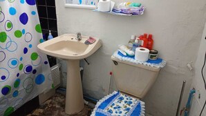 Ein Badezimmer mit Waschbecken, Toilette und Duschvorhang.