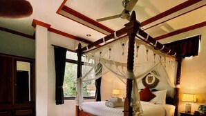 A four-poster bed with a canopy, wooden headboard, and a ceiling fan. - The Nest in Ubud (Ubud)