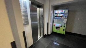 A hallway with a vending machine and an elevator. - Nest Aparthotel kitchenette  (New York)