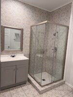 Bañera con ducha, toallas, jabón, shampoo