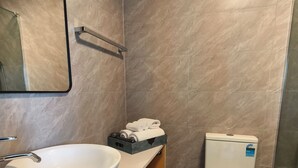 Une salle de bain moderne avec un lavabo blanc, des toilettes et un miroir.