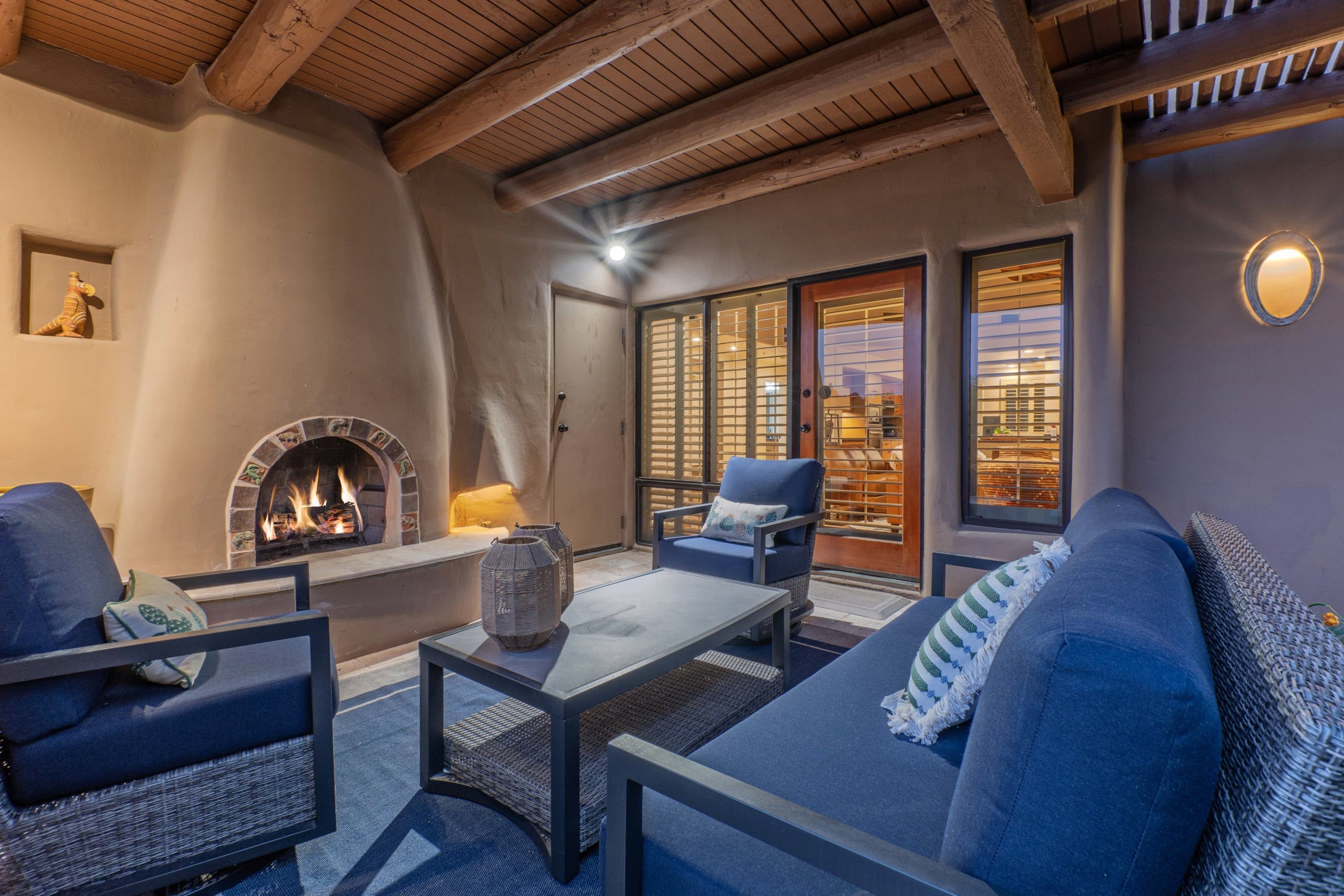 Un rincón tranquilo con chimenea, asientos y vistas al exterior.