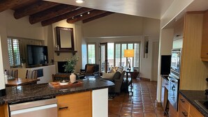 Una cocina amplia con una isla central, armarios de madera y piso de baldosas.