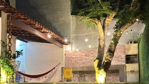 A well-lit outdoor area with a hammock, a brick wall, and string lights.