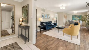 A living room with a sofa, armchairs, a coffee table, and a console table with lamps.