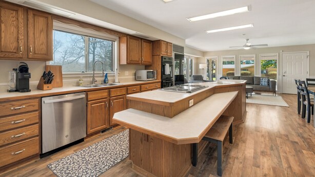A modern kitchen with wooden cabinets, stainless steel appliances, and a large island.