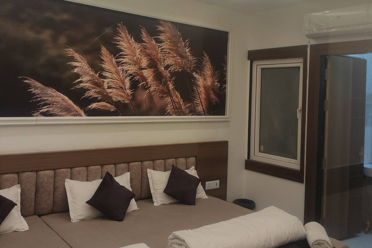 Une chambre d’hôtel moderne avec un grand lit, un ventilateur de plafond et une grande fenêtre.