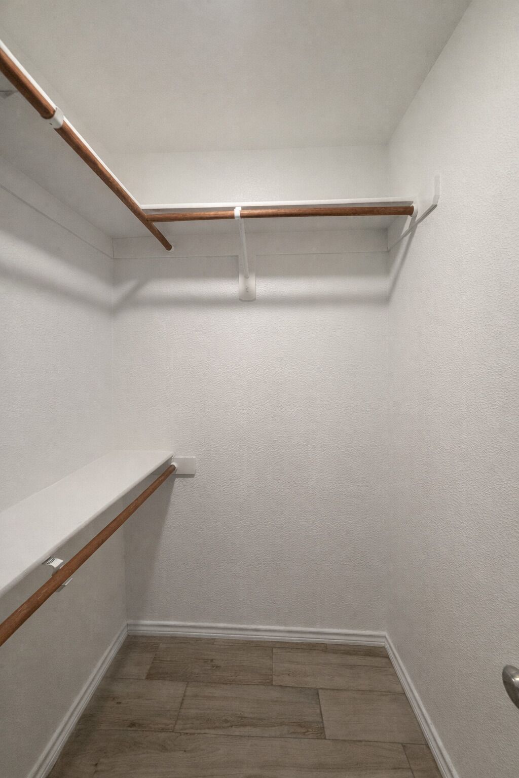 A walk-in closet with wooden shelves and a white door.