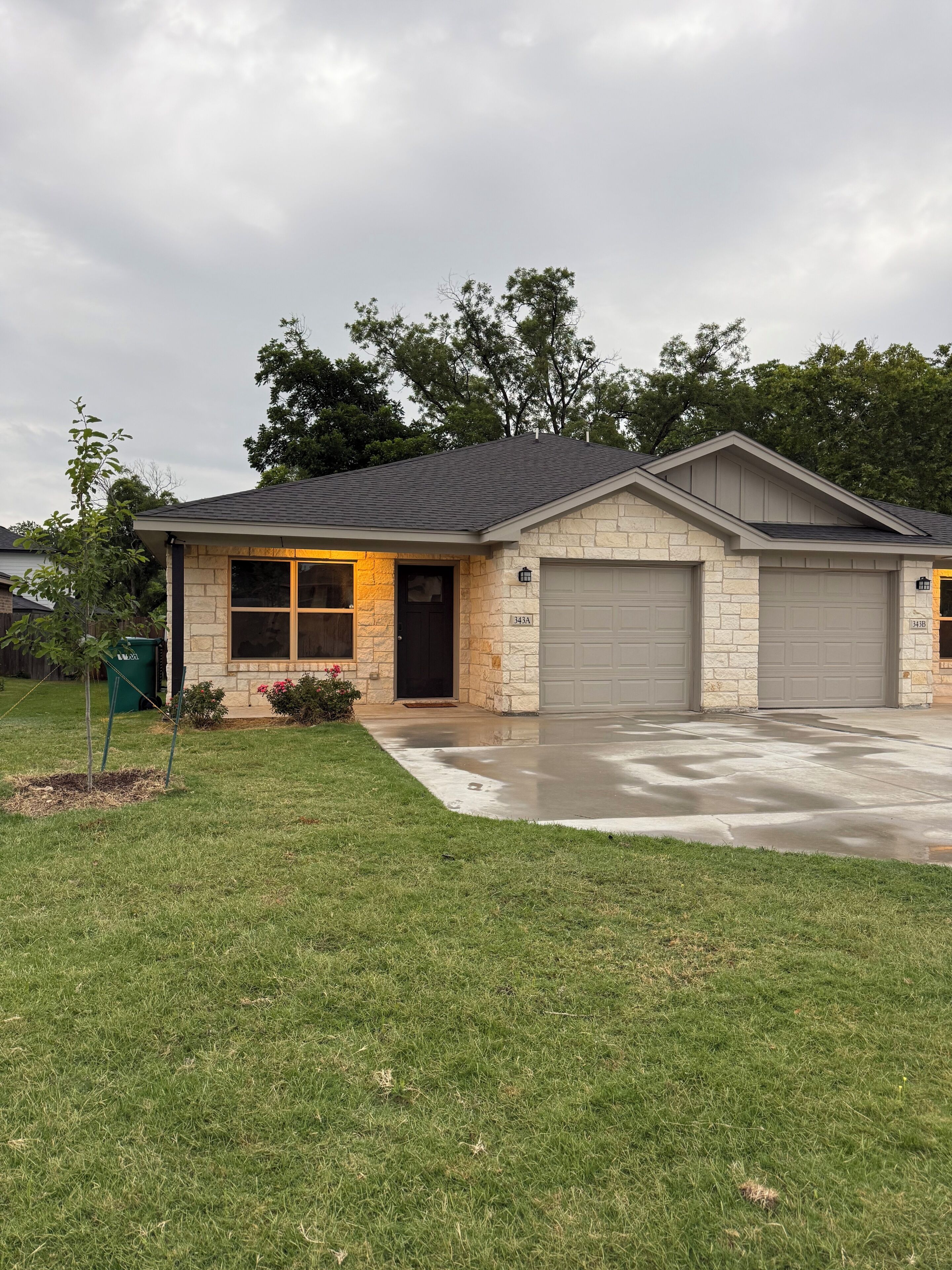 A single-story house with a garage, a front door, and a small porch area.