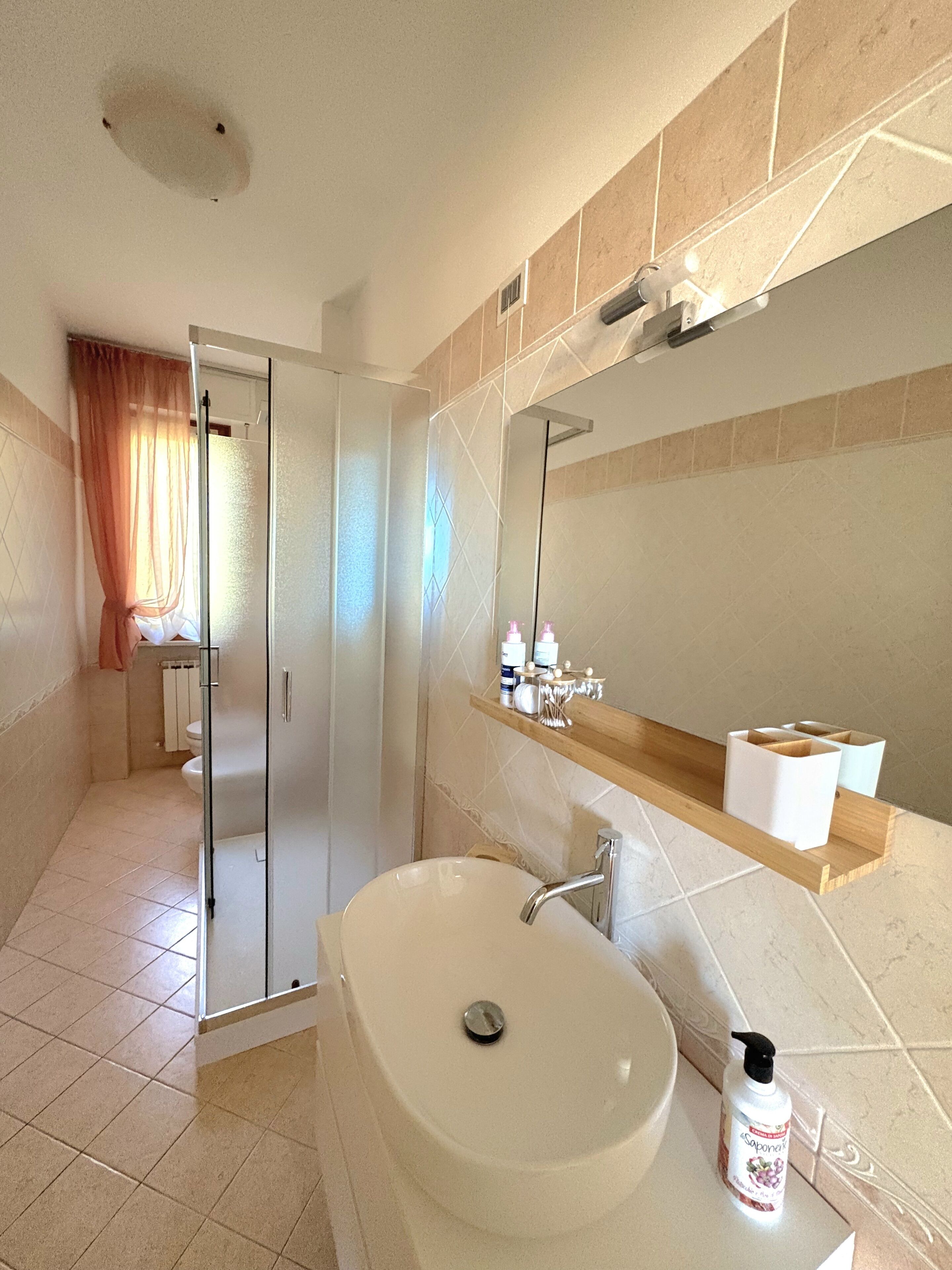 Ein Badezimmer mit Waschbecken, Spiegel und Dusche.