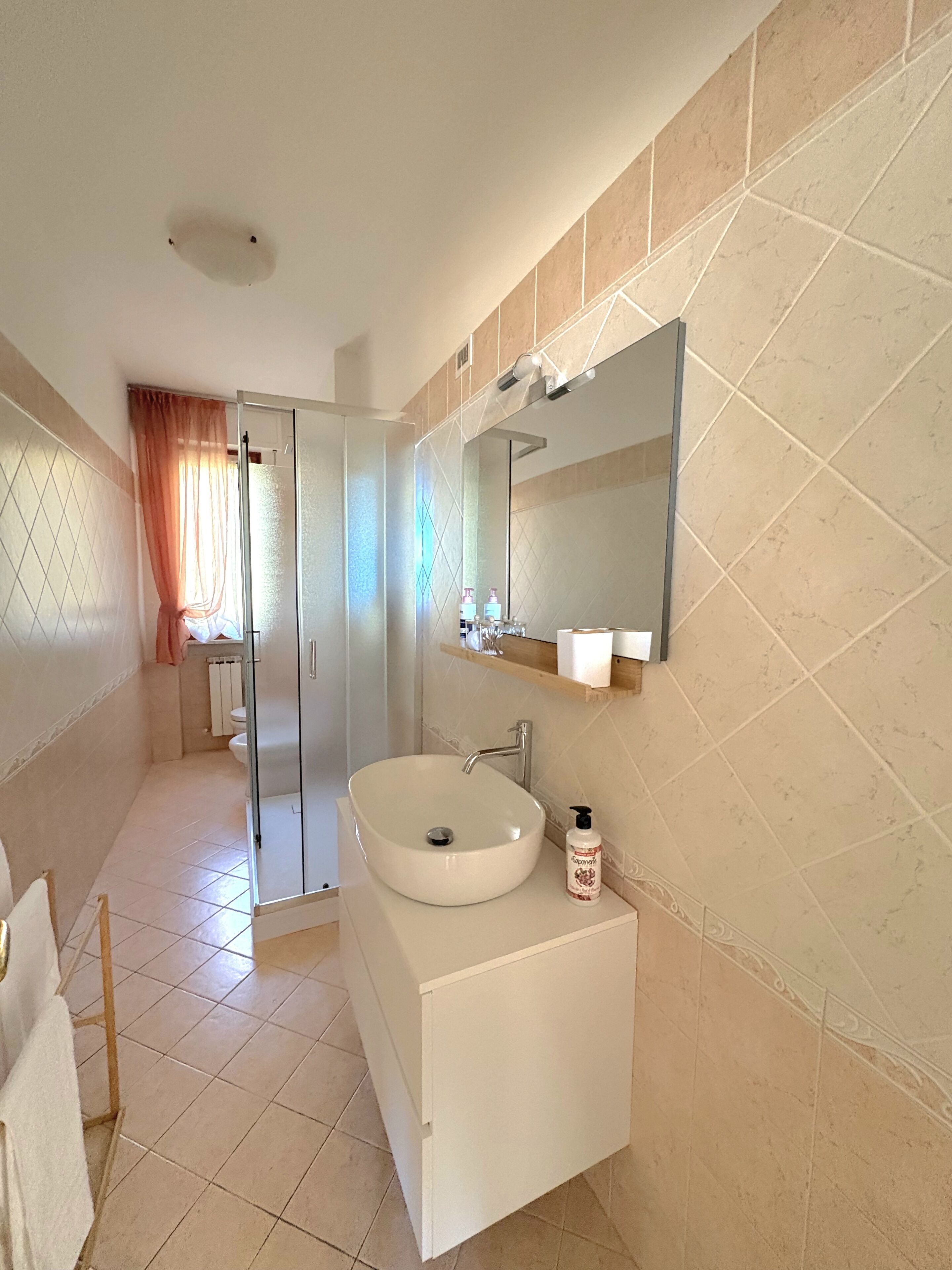 Une salle de bain moderne avec un grand lavabo, un miroir et un espace douche.
