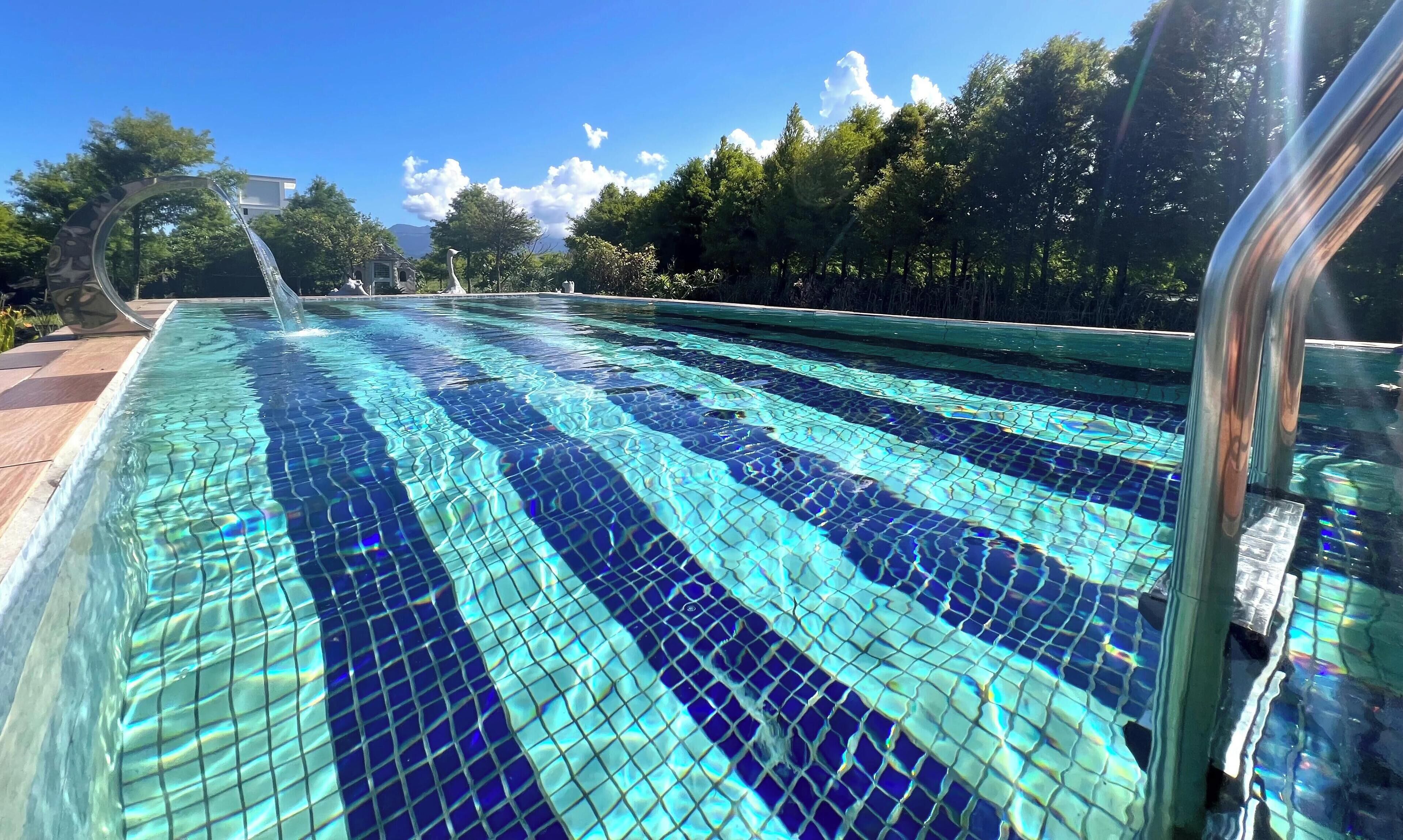 Een seizoensgebonden buitenzwembad en parasols bij het zwembad
