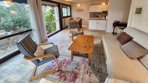 A modern living room with a sofa, chairs, a coffee table, and a view of the outdoors. - 2 rooms, WIFI, sea view, garden, private parking (ST MANDRIER SUR MER)