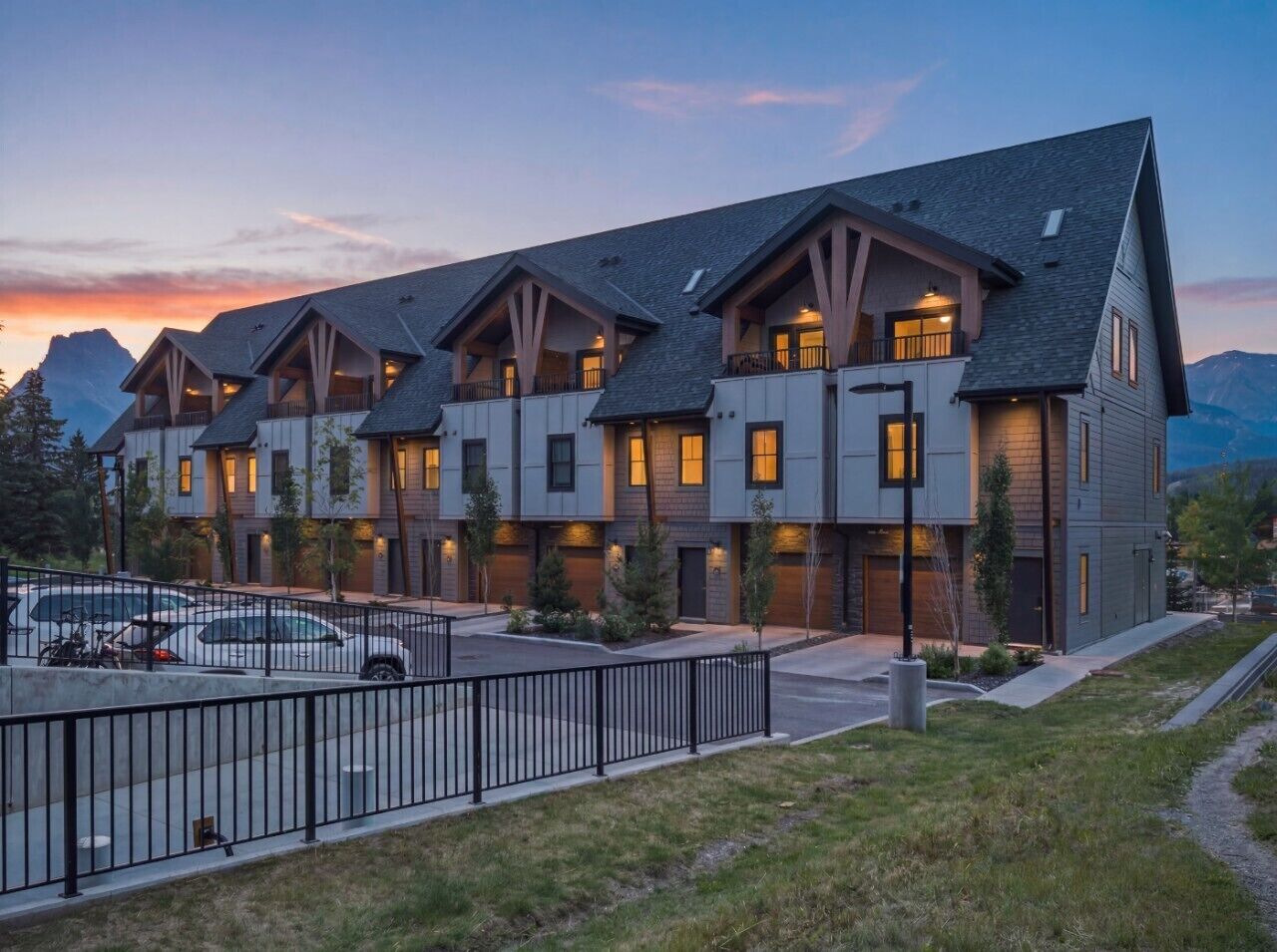 Un hôtel moderne à plusieurs étages, doté d’un parking et offrant une vue sur les montagnes.