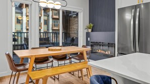 A modern kitchen with a dining area, a large window, and a built-in fireplace.