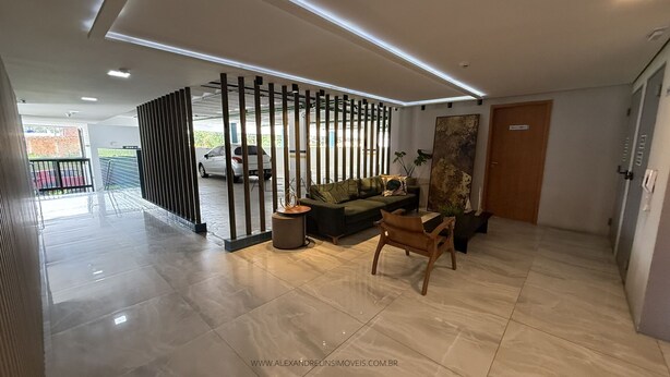 A modern lobby with a sofa, a wooden chair, a small table, and a decorative plant. - Apartment located near the beach and the shopping mall. (MACEIÓ)