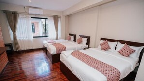 A hotel room with three beds, wooden flooring, and a window with curtains. - ye layeku boutique hotel pvt ltd (Kathmandu)