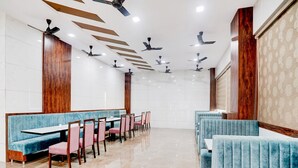 Ein geräumiges Restaurant mit hohen Decken, mehreren Deckenventilatoren und einem polierten Marmorboden.