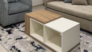 Ein modernes Wohnzimmer mit einem grauen Sessel, einem beigen Sofa und einem weißen Couchtisch.